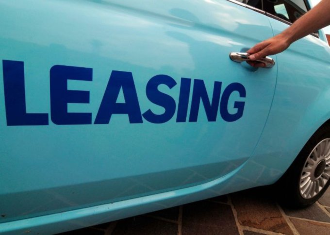 Mężczyzna wsiadający do niebieskiego samochodu z napisem leasing zna korzyści wynikające z jego umowy leasingowej